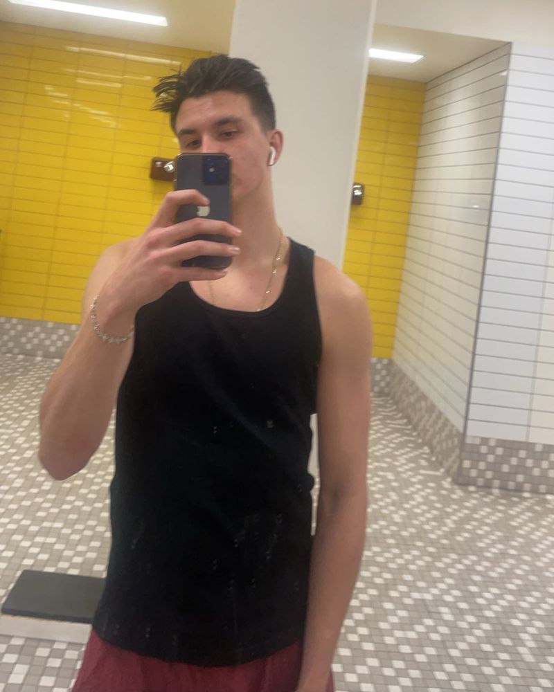 Before: Adam in a black tank top, mirror selfie